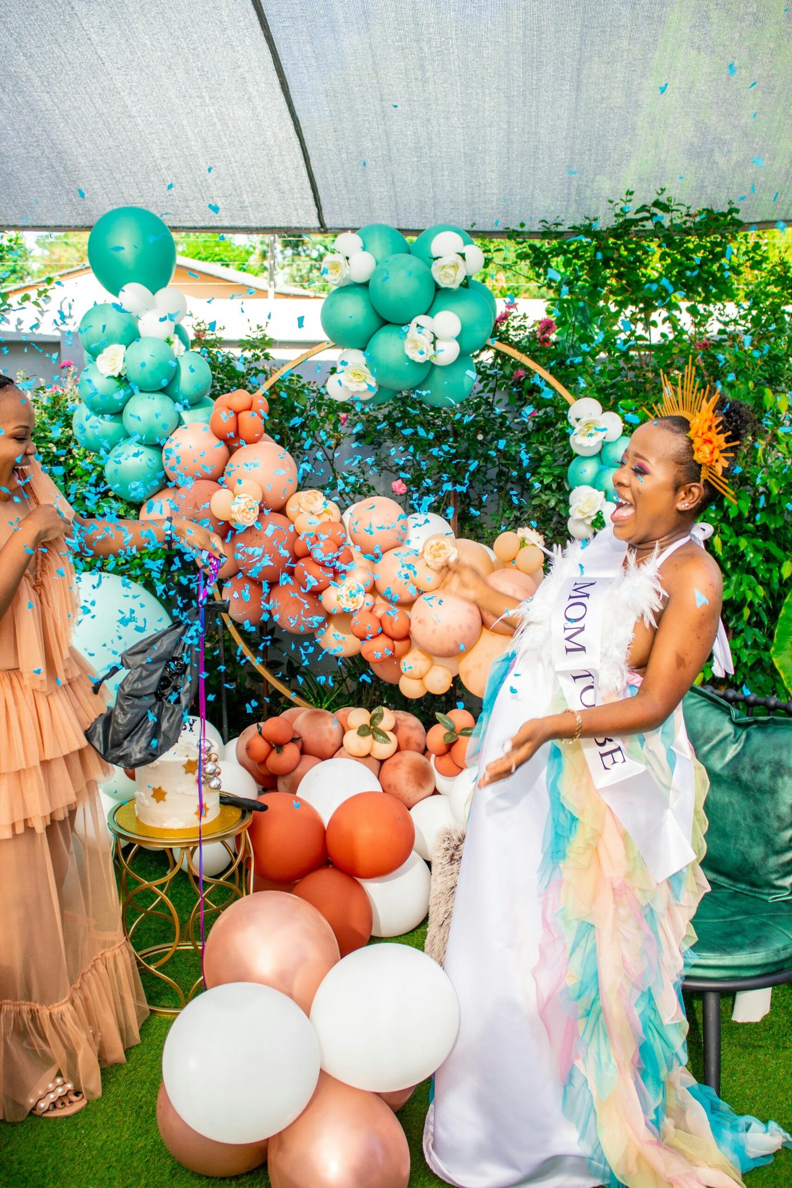 Joyful outdoor gender reveal party with confetti and balloons in Gaborone, Botswana.