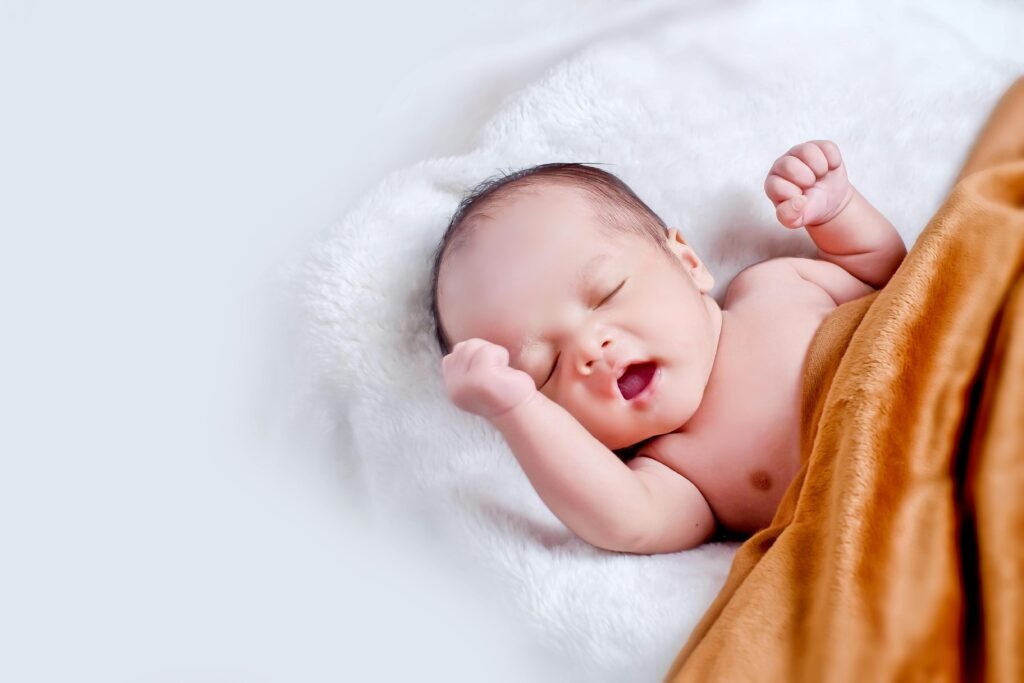 A peaceful sleeping infant wrapped in a soft, warm blanket on a cozy white surface.